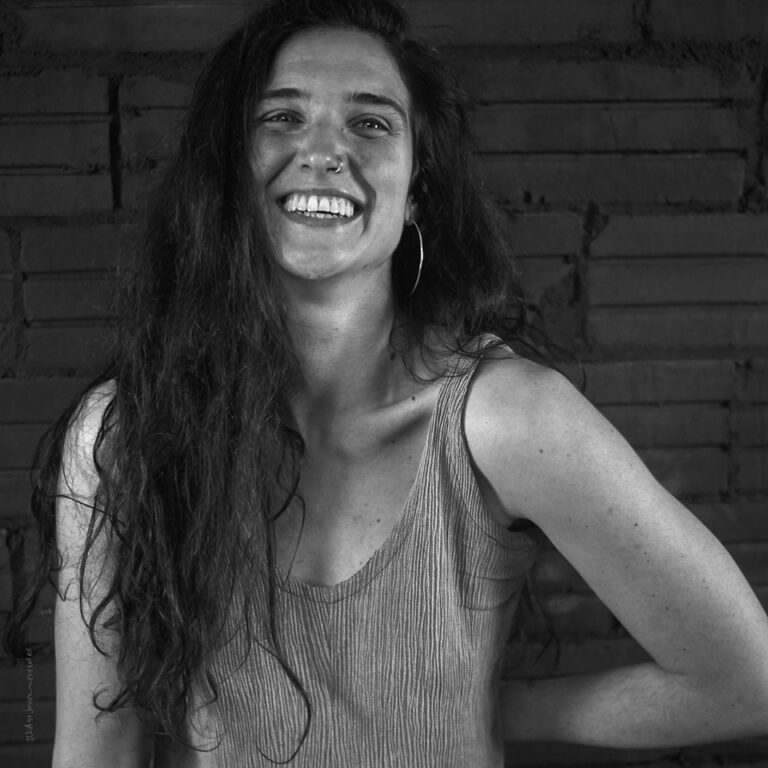 A grayscale photograph of Julia Campistany laughing at the camera