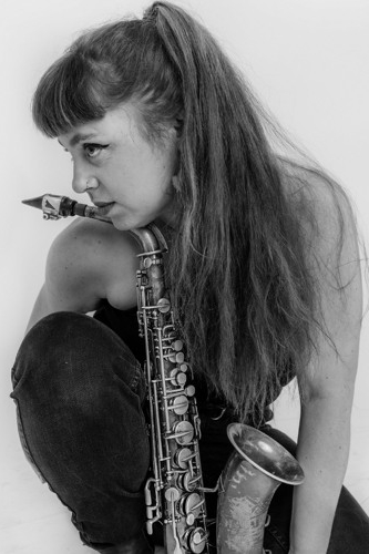 Lola Stouthamer in a grayscale portrait with her saxophone