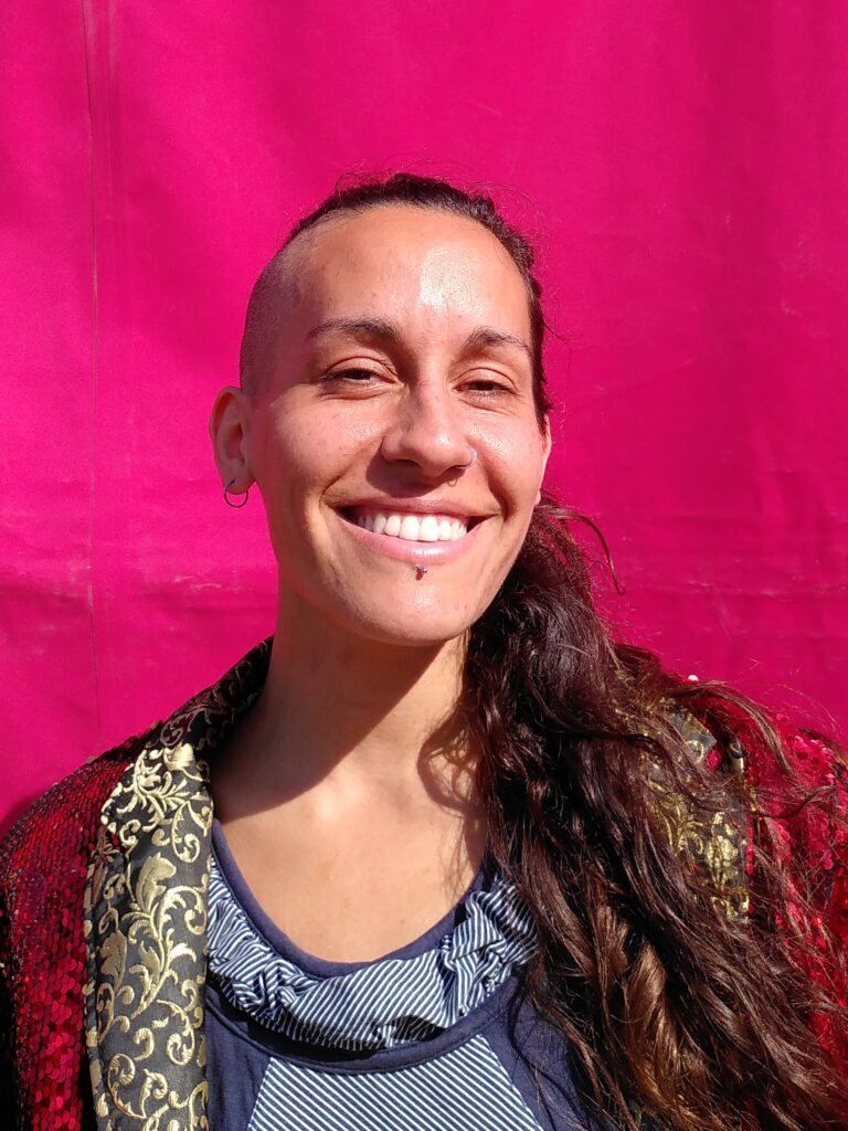 Brenda in front of the pink tent wearing a red glittery jacket